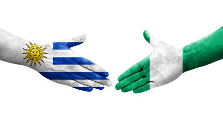 Handshake between Nigeria and Uruguay flags painted on hands, isolated transparent image.