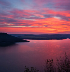 Sunset view of Bakota Bay with pink sky and water on dusk. Khmelnytskyi region, Ukraine.