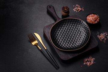 Empty black plate over dark stone background with free space