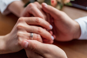 A man and a woman holding hands, newlyweds.Close-up