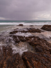 Rock formation on the coastline with cloudy sky.