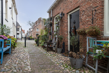 Small street with old small and authentic houses and flowers in the center of Elburg in the Netherlands.