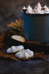 Pieces of white marshmallow on the table near a gray cup with a drink