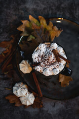 White cream on a cup with cappuccino, cinnamon sticks and star anise. View from above