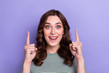 Portrait photo of young crazy woman girl directing fingers up shocked great offer proposition sale clothes isolated on pastel purple color background