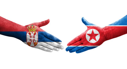 Handshake between North Korea and Serbia flags painted on hands, isolated transparent image.