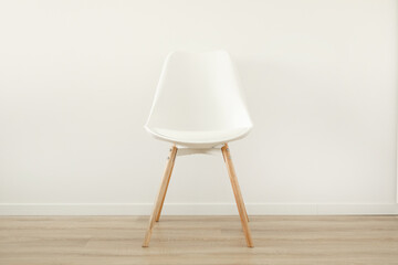A chair made of wood and white plastic stands in the room.