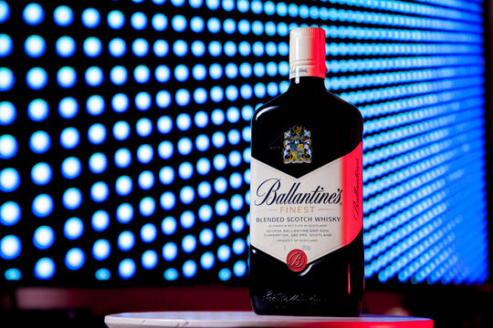 Ballantines whiskey bottle with colorful lights background in bar. Ballantines concept. Whiskey concept.