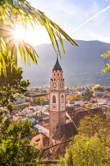 View over cityscape with Cathedral Saint Nikolaus of Merano, South tyrol, Italy seen from famous hiking trail Tappeinerweg - obrazy, fototapety, plakaty