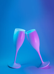 Champagne glasses clashing on a neon futuristic background. Cyberpunk, celebration, New Year concept