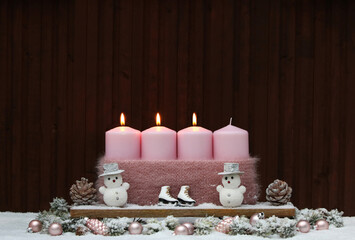 Fotoserie zur Adventszeit: Rosa Kerzen mit Weihnachtsdekoration im Schnee.