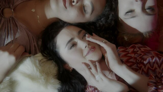 Three women lying on the floor dancing and playing with the balloons 
