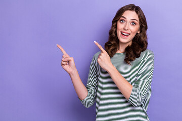 Portrait photo of young surprised woman curly hair fingers pointing empty space offer shopaholic crazy low price isolated on purple color background
