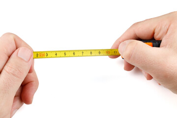 Self-retracting metal tape measure in hands. Man with measuring tape on white background