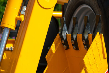 A large yellow construction excavator on a construction site. A new quarry bulldozer for the development of quarries at the exhibition of modern construction equipment. Excavator bucket close-up.