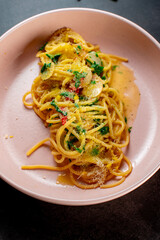 delicious appetizing classic spaghetti pasta with tomato sauce, parmesan in plate on black background