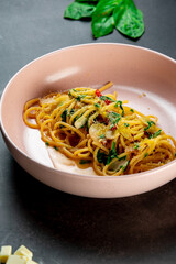 delicious appetizing classic spaghetti pasta with tomato sauce, parmesan in plate on black background