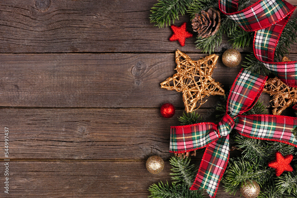 Poster christmas side border of ornaments, branches and red and green plaid bows and ribbon. overhead view 