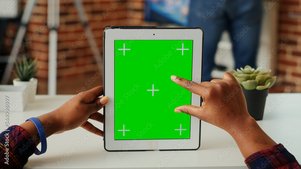Poster woman analyzing greenscreen on isolated display, vertically holding digital tablet with blank backgr