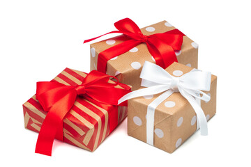 Close up set of three gift boxes wrapped in striped and dotted craft paper and decorated with satin ribbons, isolated on white background