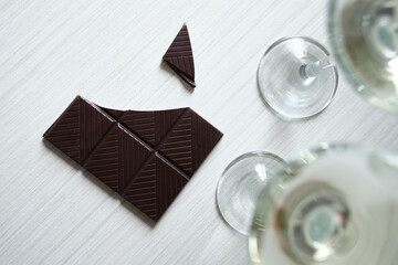 Broken dark chocolate bar top view mockup with space for text close up. Layout for design. Chocolate on a wooden white table