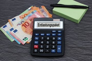 Das Wort Entlastungspaket mit Taschenrechner und Euro Banknoten. - obrazy, fototapety, plakaty