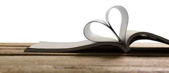 Heart from a book page on wooden desk