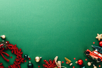 Green Christmas background with vintage decorations, balls, stars, wreath, car toy with Xmas tree. Flat lay, top view.