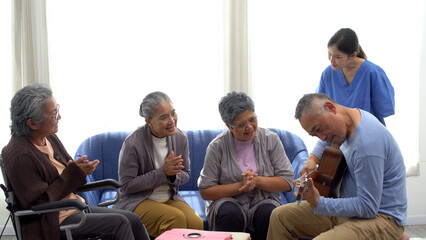 Group of enjoy asian elderly man playing music guitar with elderly friends woman and doctor in...