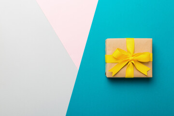 holiday paper present tied yellow ribbon bow top view with copy space. Flat lay holiday background....