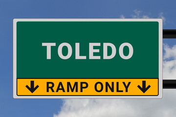 Toledo logo. Toledo lettering on a road sign. Signpost at entrance to Toledo, USA. Green pointer in American style. Road sign in the United States of America. Sky in background