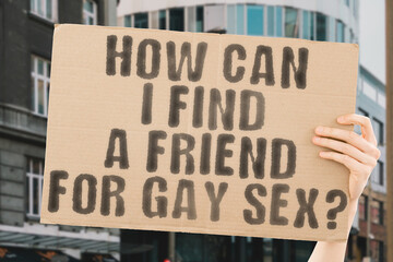 The question " How can I find a friend for gay sex? " is on a banner in men's hands with blurred background. Gay Sex. Sex. Protection. Rule. Sexual. Heterosexual. Sexuality. Problem. Hormone. Passion