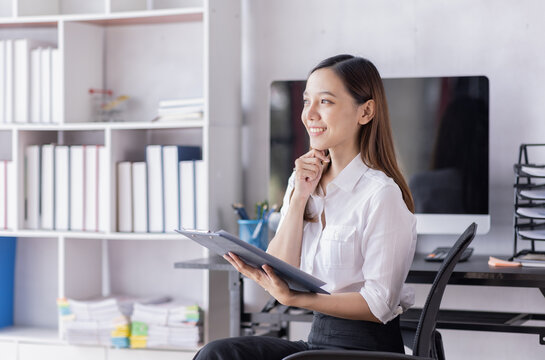 Asian Accounting businesswoman working on note laptop computer and analyzing real estate investment data, Financial and tax systems concept.

