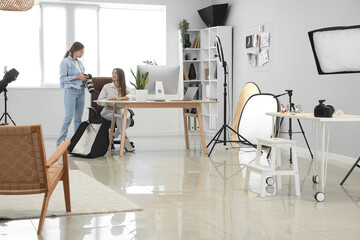 Female photographer working with assistant in modern studio