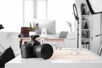 Professional photo camera on table in modern studio, closeup