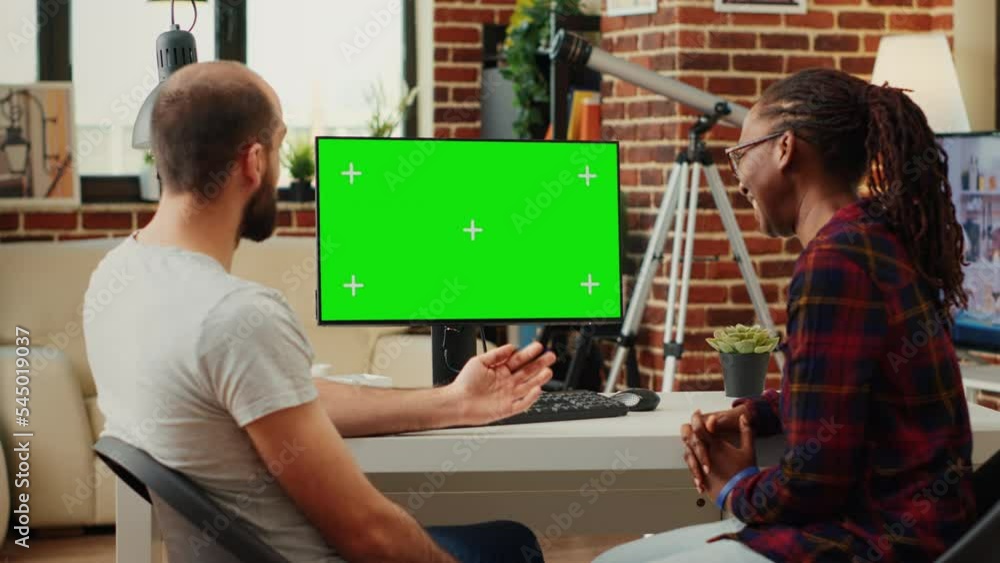 Poster diverse team of colleagues looking at computer with greenscreen, analyzing chroma key display on mon