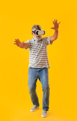 Senior man with VR glasses on yellow background