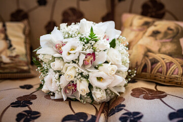 Bouquet sposa con fiori bianchi rosa e verdi e rose  abbandonato su un letto