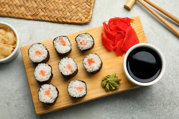 Tasty sushi rolls served on grey table, flat lay