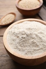 Fototapeta na wymiar Quinoa flour in bowl on wooden table