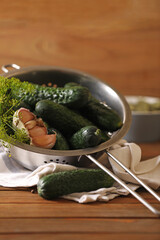 Fresh cucumbers, dill and garlic on wooden table. Pickling recipe