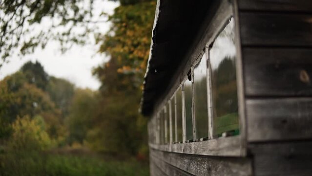 Beautiful barn outisde in the middle of the forest while raining.