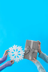 Women with Christmas gift box and snowflake on blue background