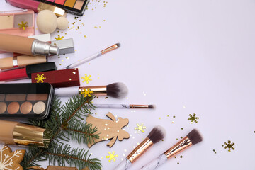 Makeup products with Christmas branches on white background