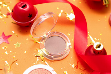 Obraz premium Makeup product with Christmas decor on orange background