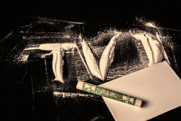 1 US dollar bill, rolled into a tube, on white powder in the form of the letters TV. Conceptual idea of fakes, lies on television, in the media.