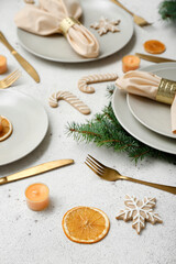 Beautiful table setting with Christmas branches, cookies and dried citruses on white background, closeup