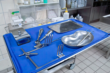 Surgical instruments and tools such as scalpels, forceps and tweezers are placed on the operating table.