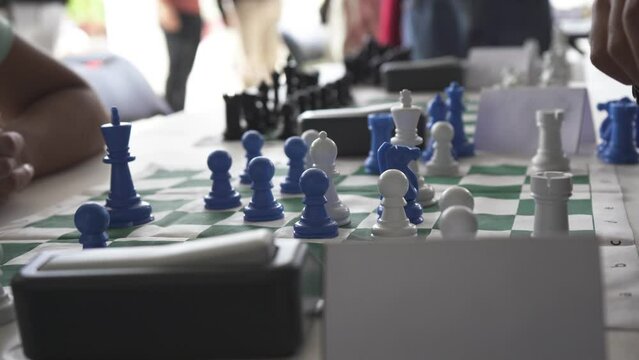 Chess movements of young players in tournament, black and bluechess pieces
