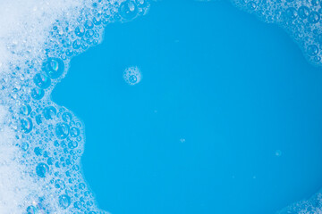 Detergent foam bubble, blue background.